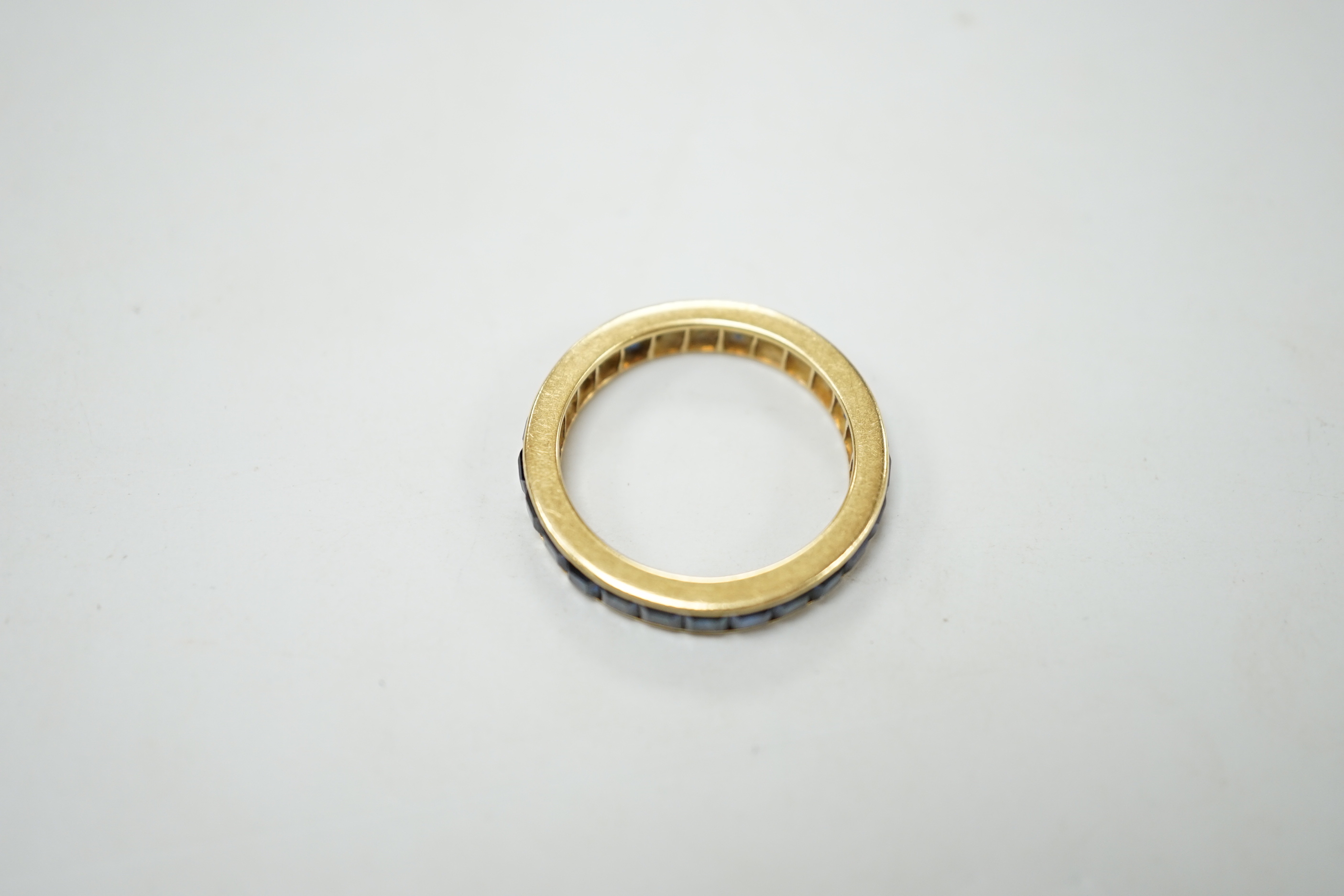 A yellow metal and sapphire set full eternity ring, size R, gross weight 4.6 grams.